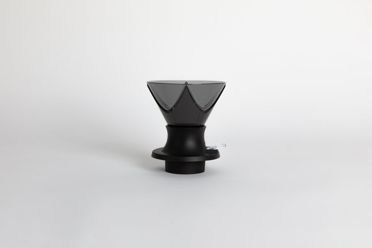 Translucent black plastic cone shaped dripper with Bézier ridges in a black silicone base with clear plastic push switch