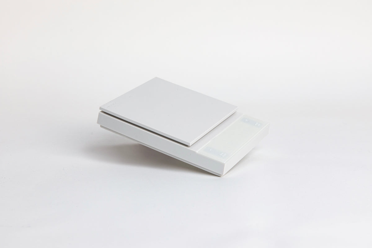 white digital square scale with a flat surface and clear LED display. set on a white background.