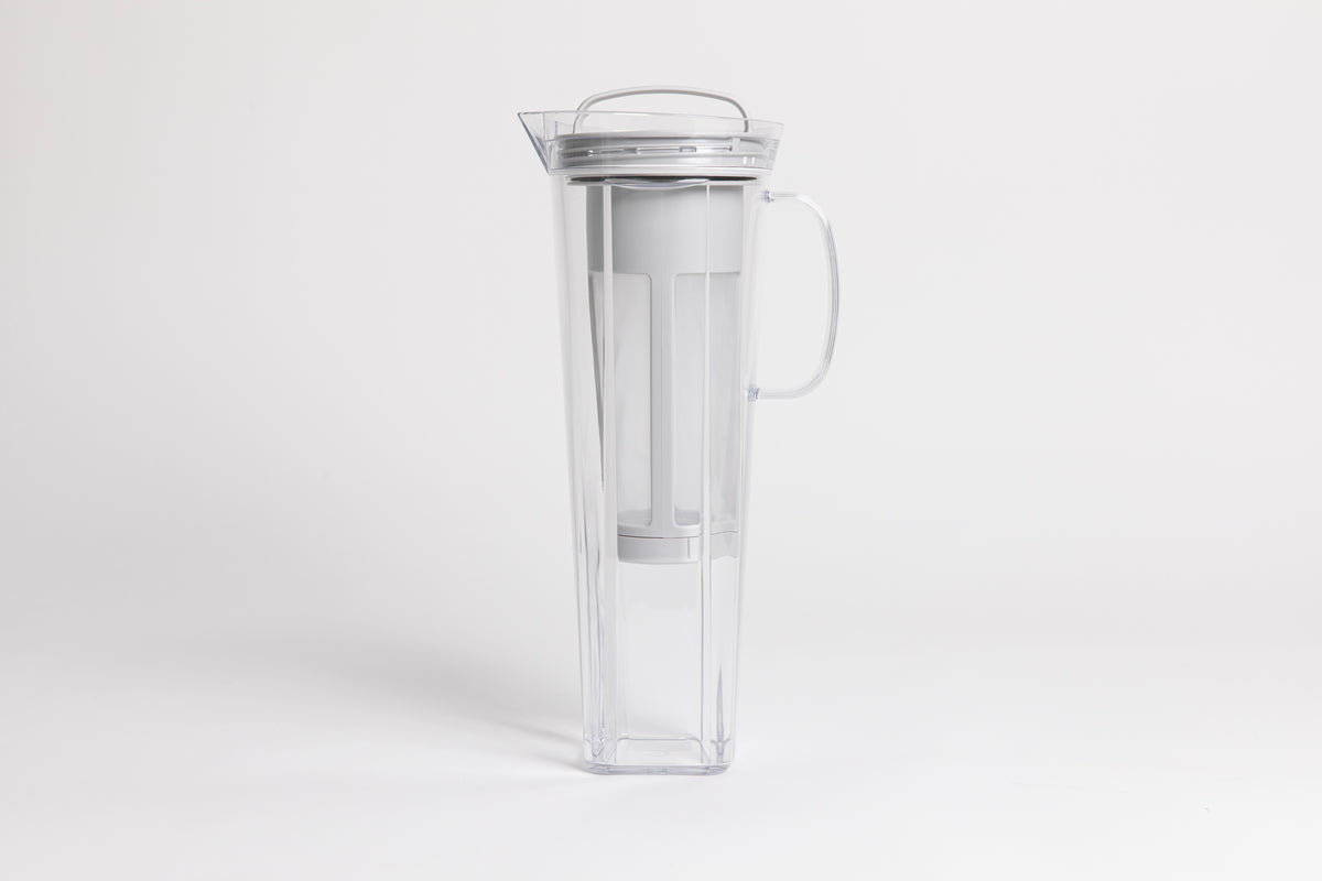 Tall plastic clear server with pale gray nylon mesh coffee filter insert and white plastic handle and lid. set on a white background