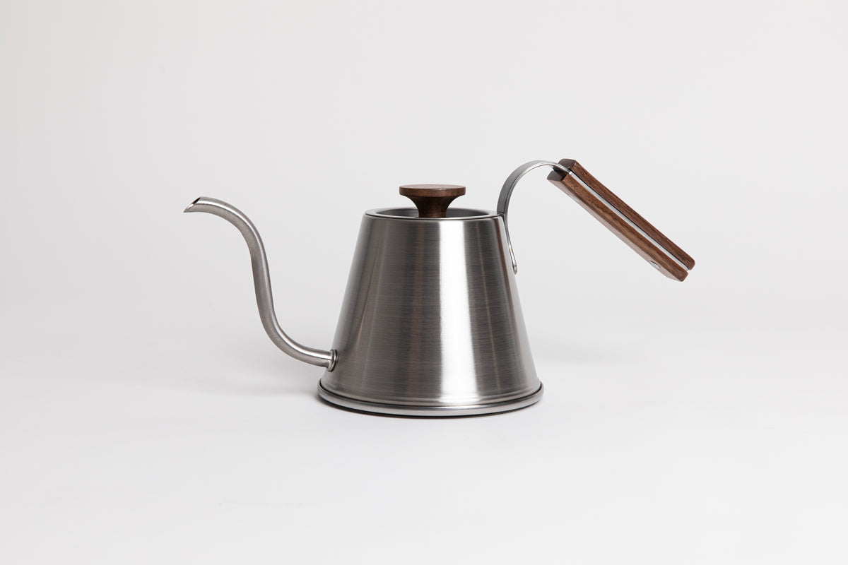 Stainless steel kettle with gooseneck spout, wood handle and flat, wood lid knob set against a white background.