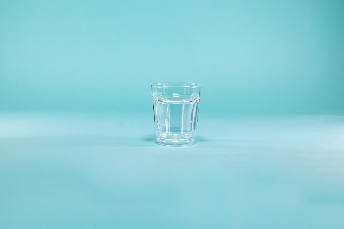 Double wall clear rock glass on a blue background.