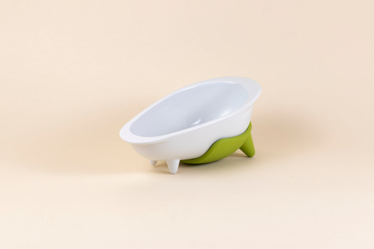 White glazed porcelain dog bowl shaped like a bathtub with pistachio green silicone non-slip mat.