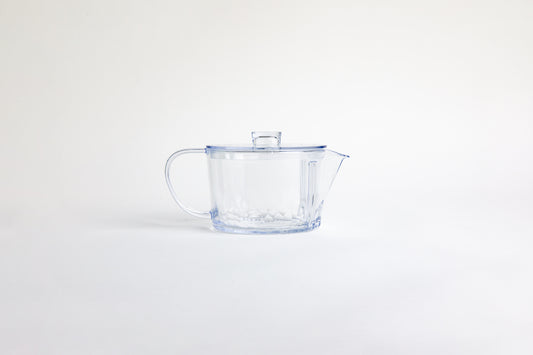 Clear ribbed clear plastic teapot with clear lid and clear handle. set on a white background