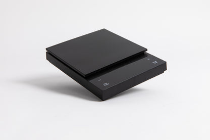 Sleek black digital square scale with a flat surface and clear LED display. set on a white background.
