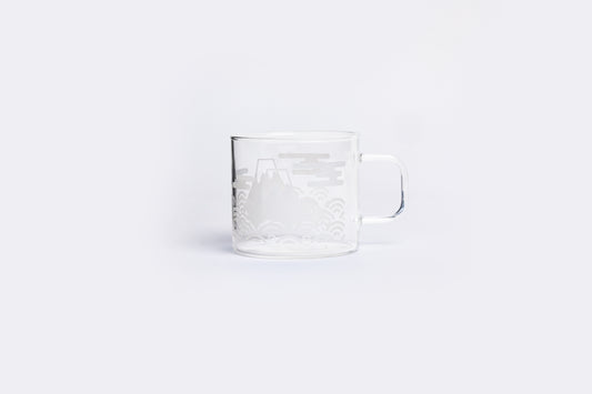 Clear glass mug with embossed design on a white background