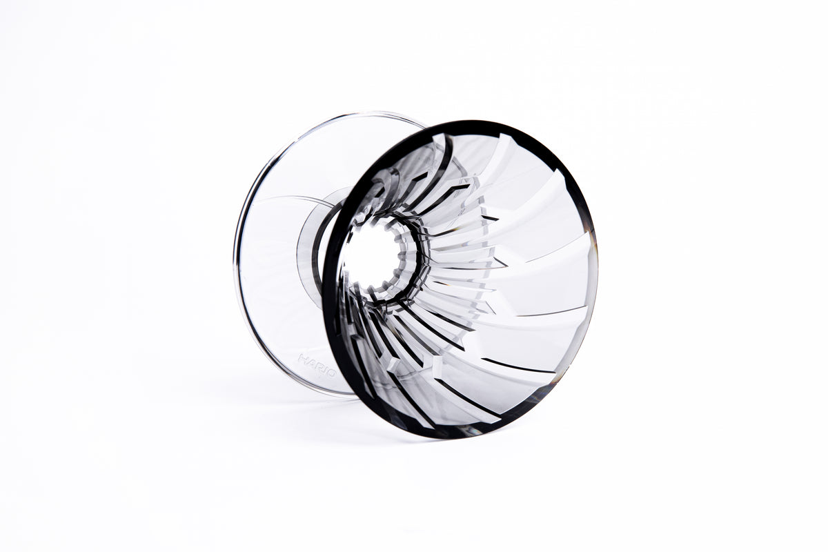 clear gray plastic cone dripper showing interior ribbing on white background.