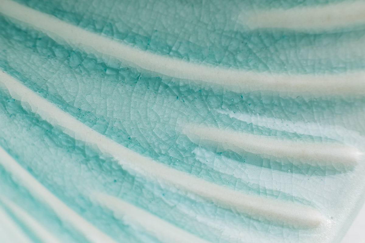Close-up of the interior of a teal-colored pour-over cone, showcasing the crackle teal glaze finish. The raised ribs inside the cone are white