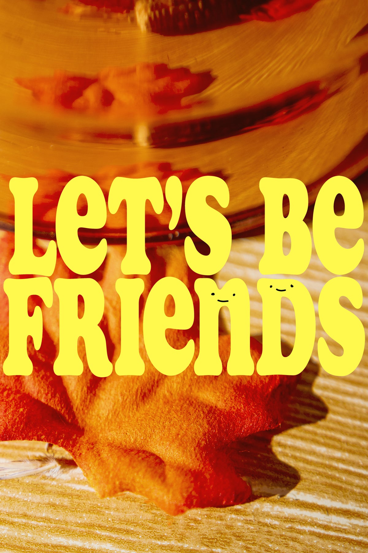 Close up of an autumn leaf, and a copper kettle on a wooden surface, with the text 'Let's Be Friends' in Yellow over top the image.