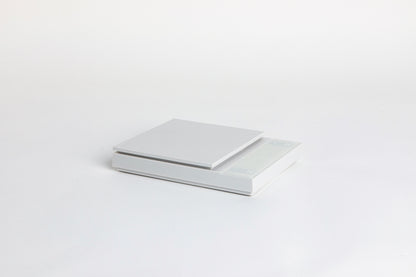 white digital square scale with a flat surface and clear LED display. set on a white background.