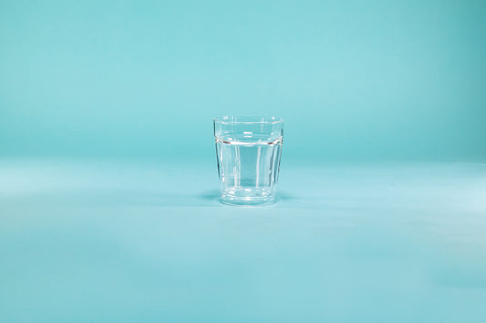 Double wall clear rock glass on a blue background.