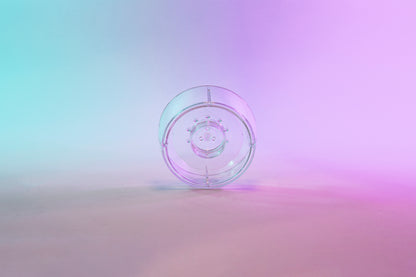 Clear plastic ring with interior smaller ring and holes for liquid to drain through. Set on a blue to purple gradient background.
