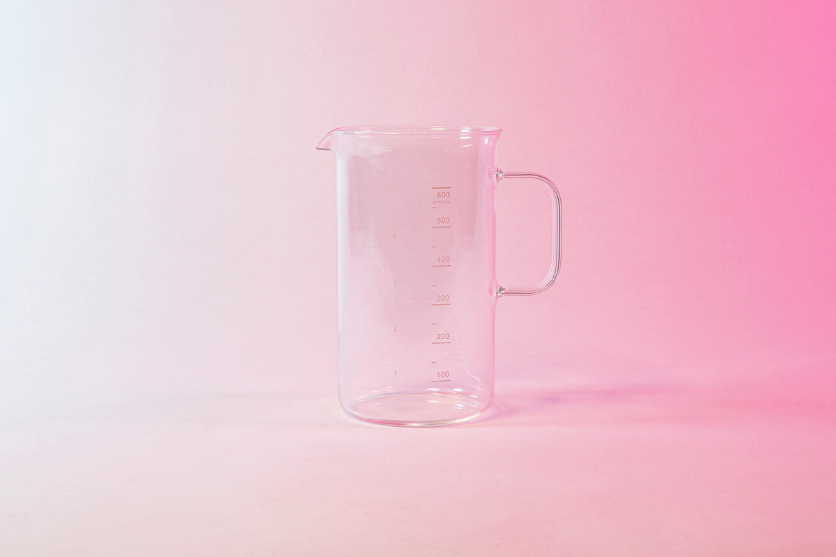 Clear glass coffee server with milliliter markings from 100 to 600 and full glass handle.